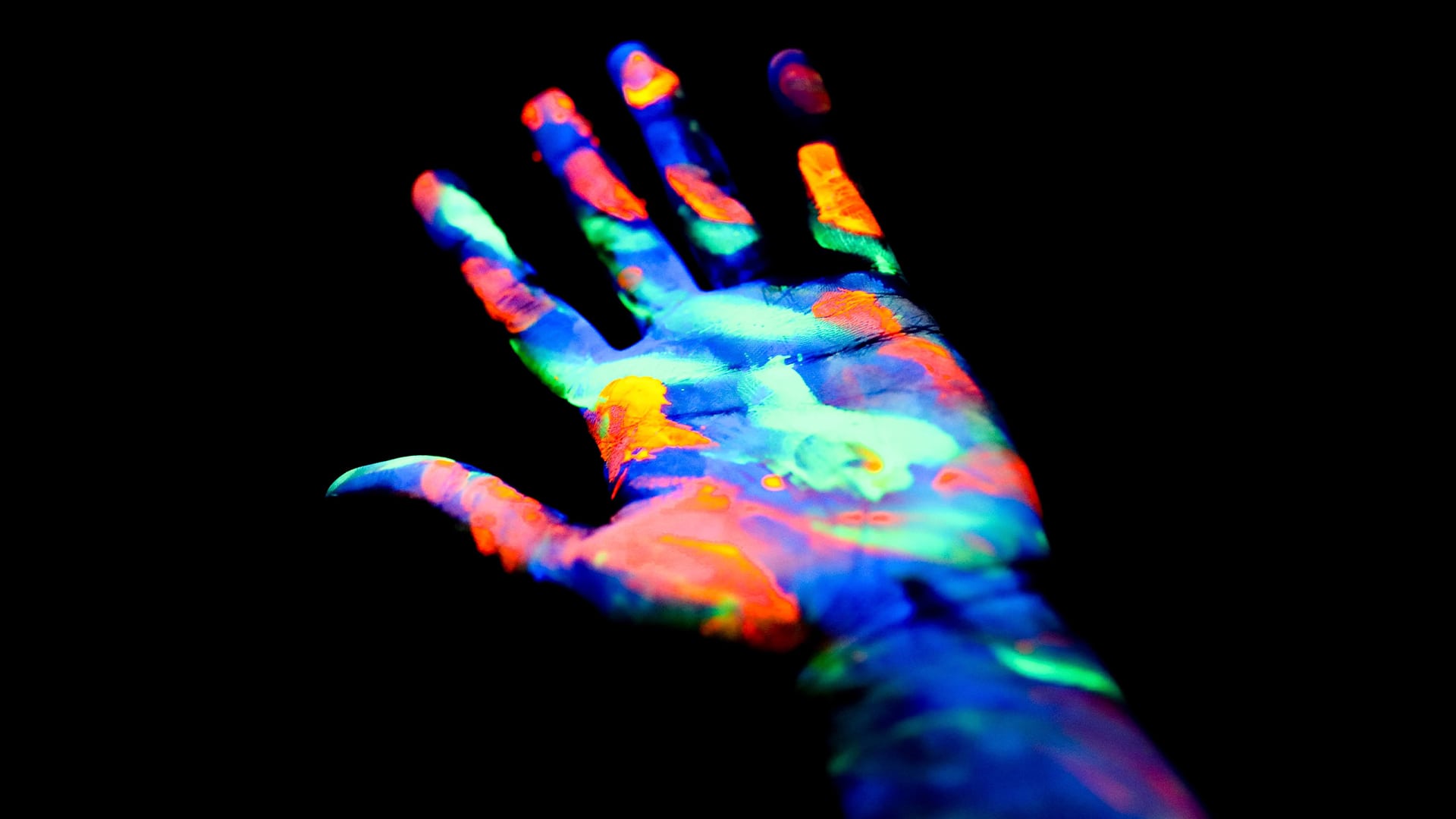 Human hand with palm up painted colorfully.